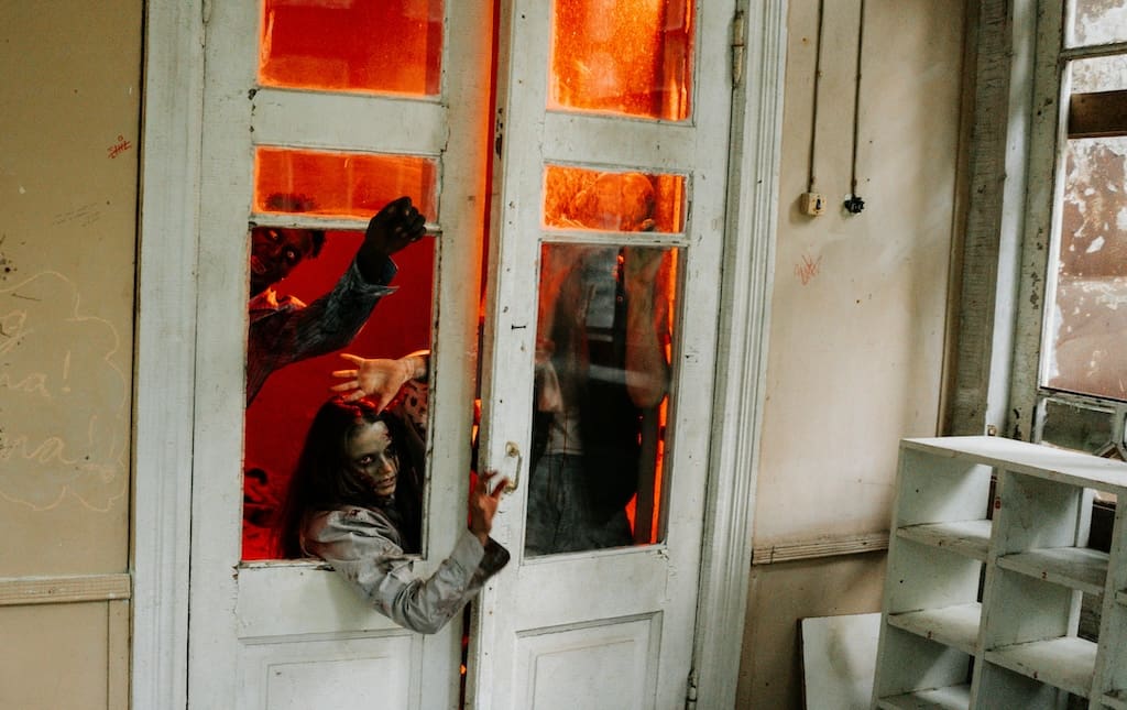 People coming out of a window in a pretend haunted house