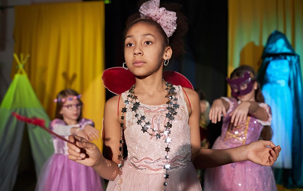 Kids dressed in fun costumes getting ready to go on stage during a fashion show.