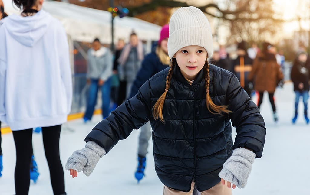 Kids skating at an outdoor ice rink at a community skate night.