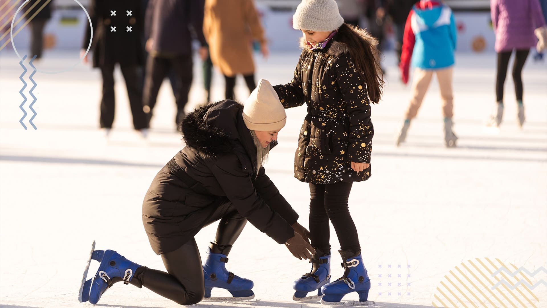 Mother helping her daughter with her skates on the ice of an outdoor skating rink with other skaters in the background