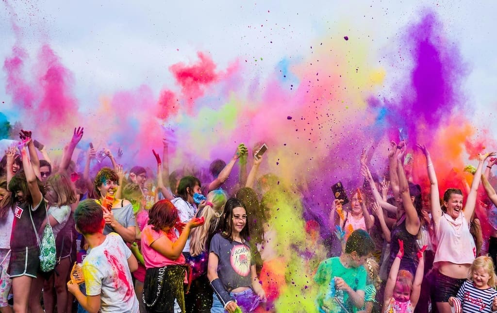 Group of people of all ages celebrating in a color run