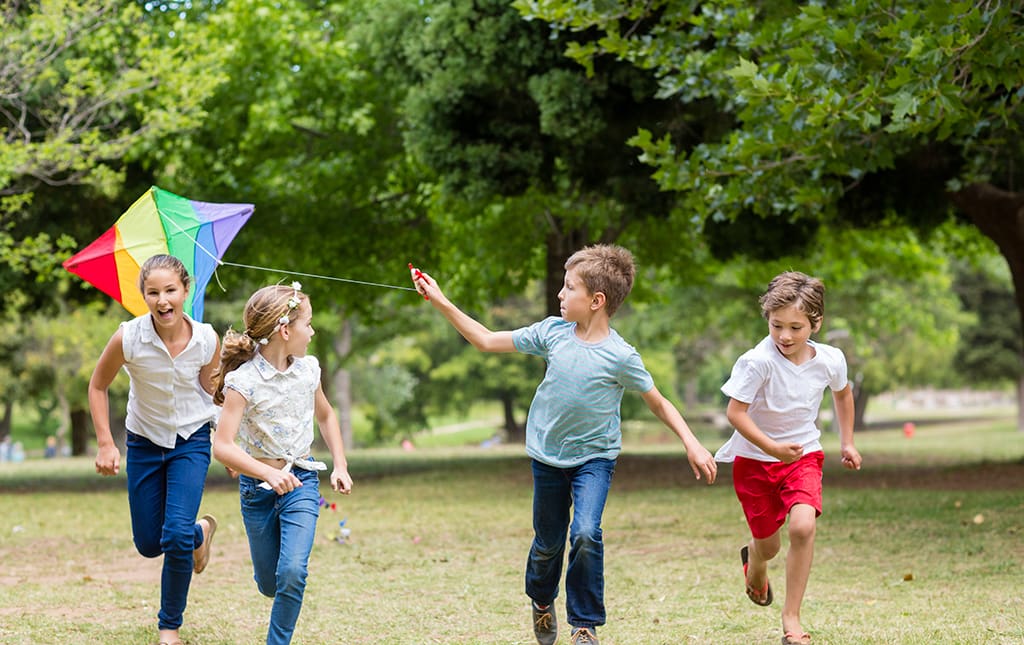 Kids running and flying a kite during a move-a-thon