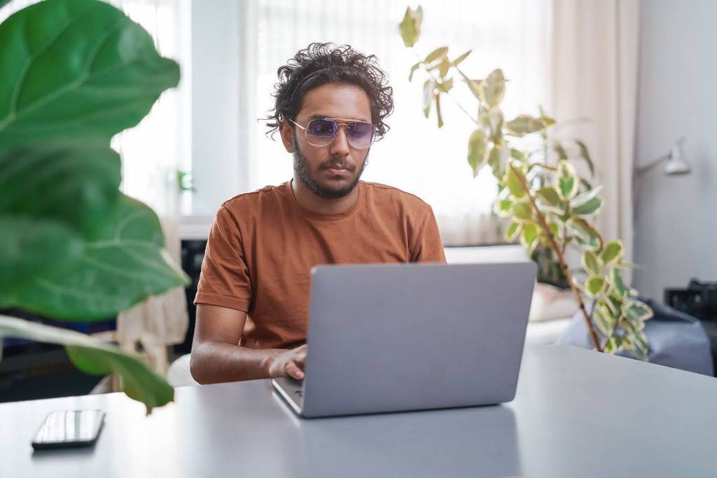 Man sitting at laptop using GoFundMe for personal fundraising campaign