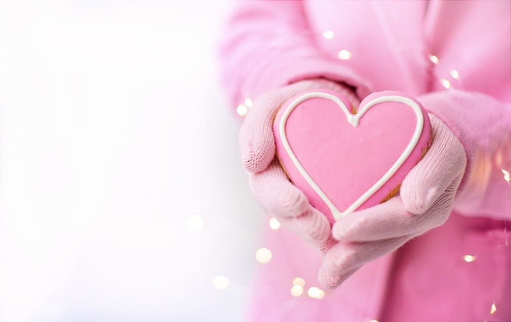 Child holding a pink heart cookie