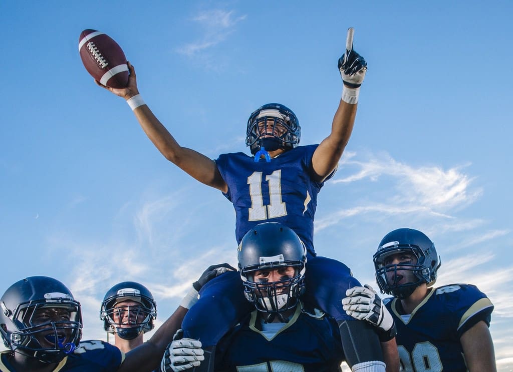 High school football players celebrating after fundraiser