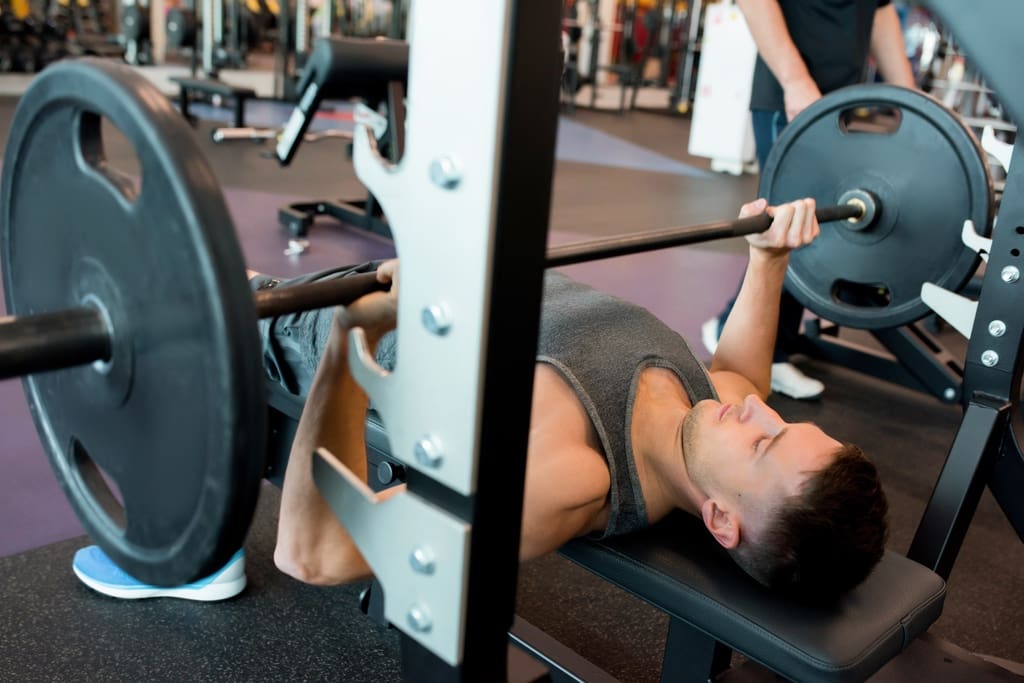 High school student bench-pressing weight in school gym