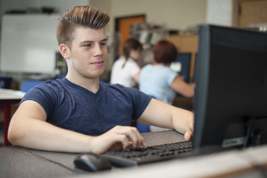 Student watching hype video for school fundraiser on computer in classroom